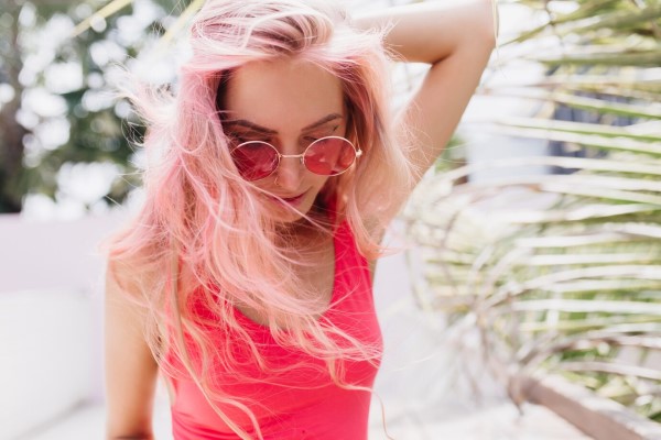 El sol daña el cabello - mujer con el cabello teñido paseando por el parque