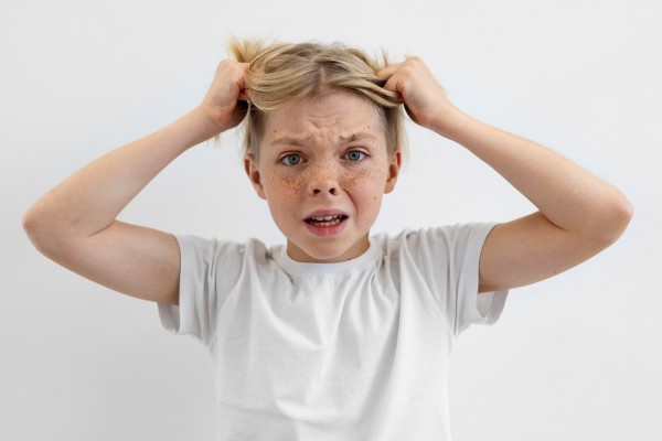 alopecia en niños - niña tirando de su cabello con ambas manos