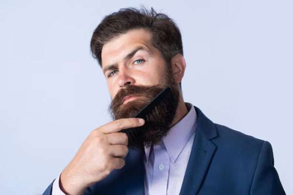 Cuidar la barba - Caballero con ropa de vestir cepilla su barba para terminar de darle los últimos toques a su look 