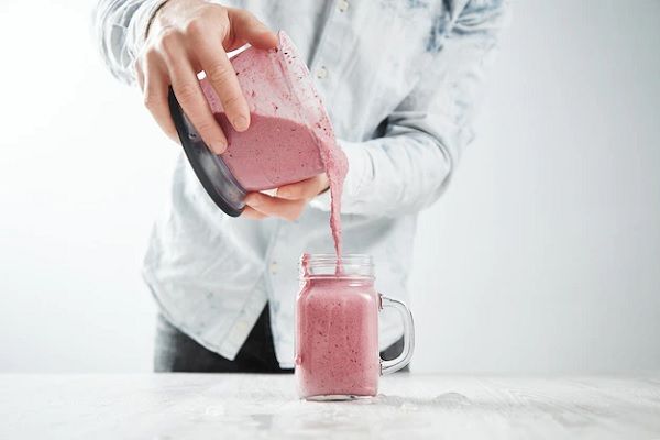 batidos de proteína y calvicie - hombre vertiendo sobre una jarra un batido