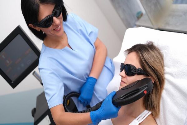 hirsutismo hormonal - mujer en la consulta de la especialista recibiendo un tratamiento de depilación