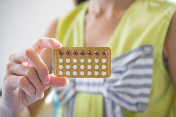 Mujer sostiene en su mano un paquete de pastillas anticonceptivas