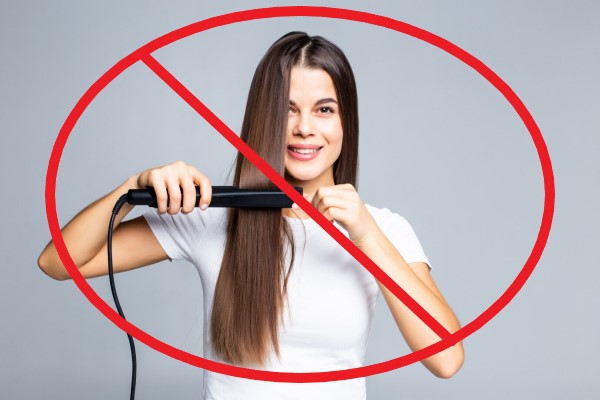 Tricorrexis nudosa -mujer joven usando una plancha para el cabello