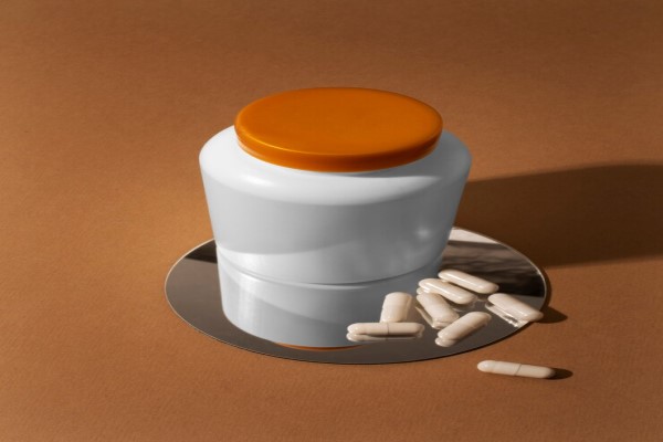 bote de capsulas sobre un espejo con capsulas diseminadas por el espejo