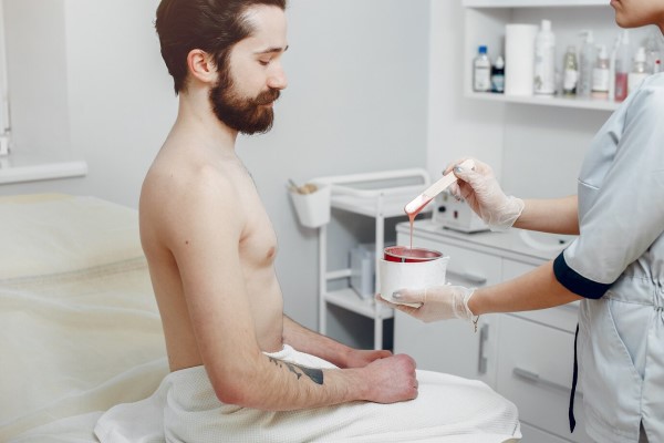 hombre en un salón de belleza para depilarse a la cera