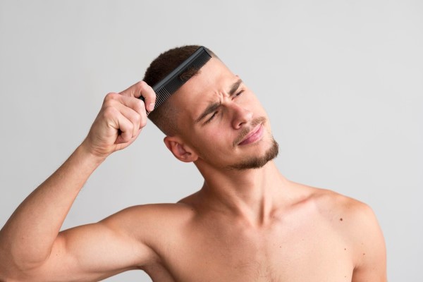 Efecto Shedding - hombre joven con efecto shedding peinando su pelo corto