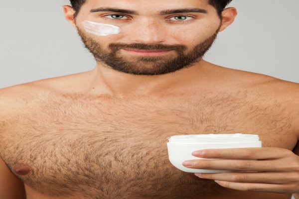  hombre con mucho vello aplicándose una crema facial