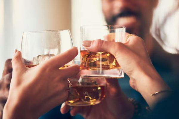 Caída del cabello - Plano detalle de un grupo de personas brindando con alcohol 