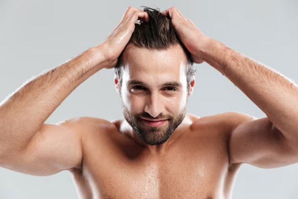 Hombre feliz disfruta de los resultados de un tratamiento capilar y de un cabello más fuerte y abundante 