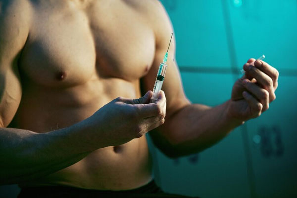 Esteroides anabólicos y alopecia - Hombre se inyecta testosterona para aumentar el tamaño de los músculos 