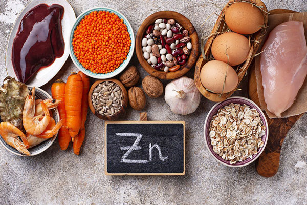 Plano cenital de huevos, hígado, avena, ajo, pollo y muchos otros alimentos ricos en zinc 
