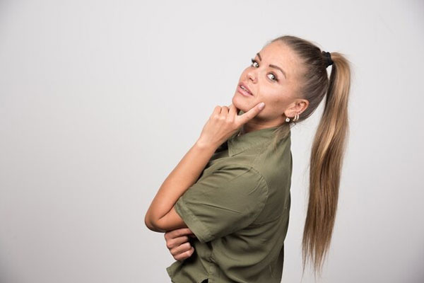 Peinados que debes evitar - Mujer de perfil y con coleta alta favorece el maltrato y el quiebre del cabello