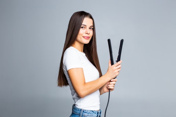 joven con unas planchas para el cabello una de las causas principales para los pelos quemados