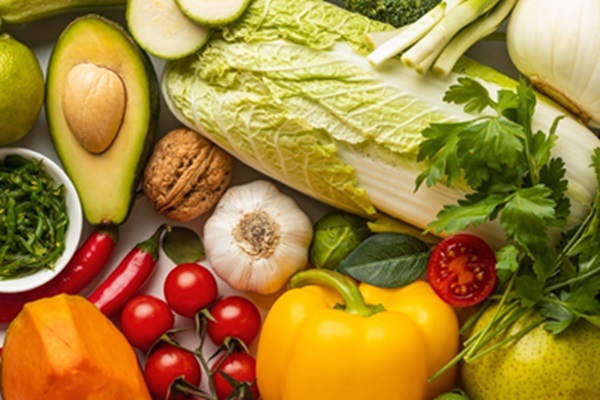 Frutas y hortalizas como aguacate, lechuga, cebolla, tomate, pepino y cilantro sobre una mesa para una dieta saludable