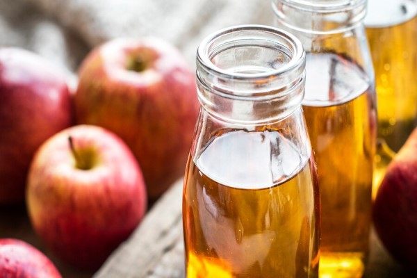 frascos de vinagre de manzana y un producto natural para ayudar en el desenredado del cabello