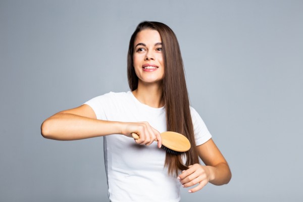 joven cepillando el cabello empezando por las puntas para mejorar el proceso de desenredar el pelo