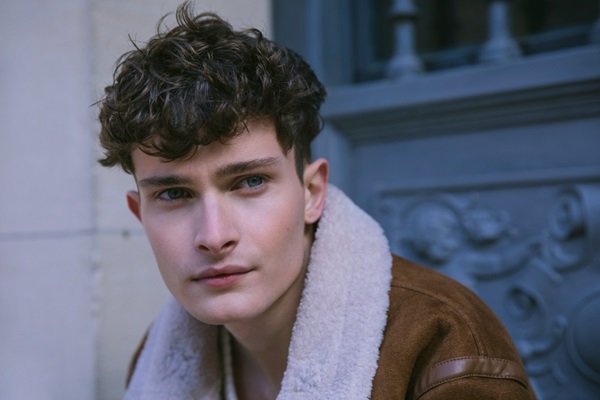 Hombre con un corte de cabello estilo flequillo posando con la mirada al horizonte