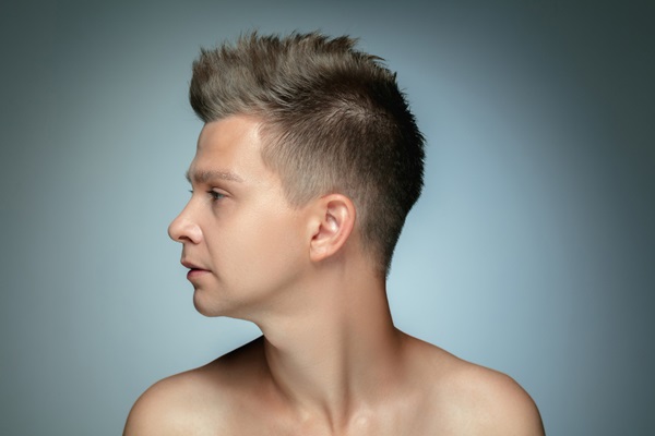 Cortes de pelo para hombres - Hombre de perfil con un corte de cabello disparejo y rebelde que refleja personalidad