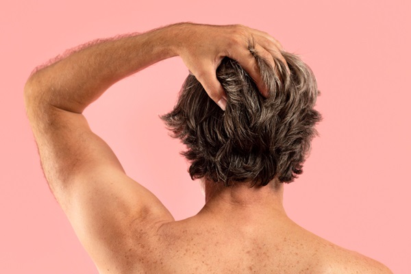 Pelo de los hombres - Hombre de espalda tocando su cabello abundante y grueso