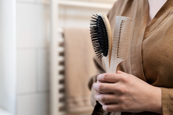 Pelo graso - Persona sosteniendo en sus manos un peine y cepillo de cerdas suaves para peinar el pelo
