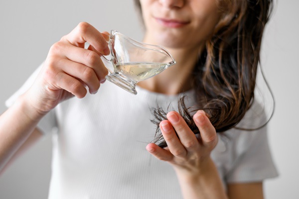 Mujer aplicando un aceite natural en su cabello para hidratarlo