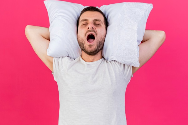 Roncar provoca alopecia - Hombre durmiendo con la boca abierta y los brazos bajo la almohada