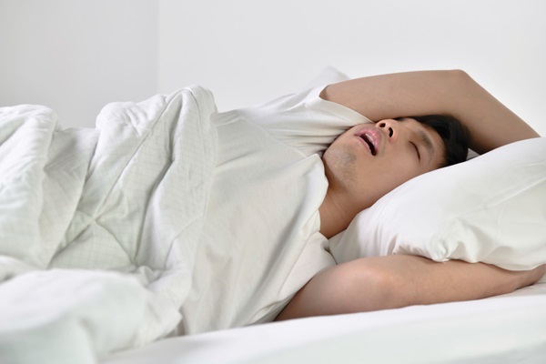 Roncar provoca alopecia - Hombre acostado en la cama para dormir con la boca abierta roncando