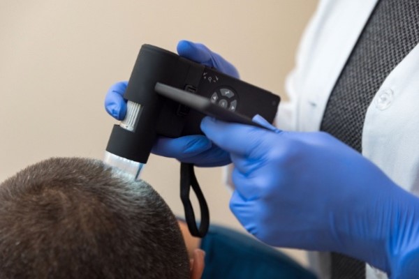 cuidar el cabello trasplantado - imagen de un tricólogo realizando una evaluación de los resultados finales de un trasplante capilar