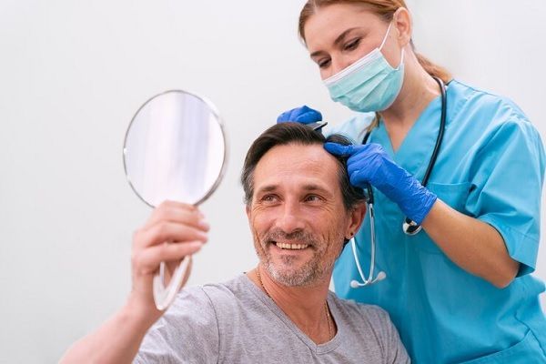 Beneficios psicológicos del trasplante capilar - Tricólogo evaluando el cuero cabelludo de un hombre luego del tratamiento de trasplante capilar CDMX