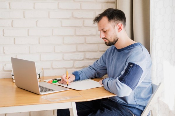 profesionales de injerto capilar - Hombre investigando en su computadora los mejores profesionales en injerto capilar