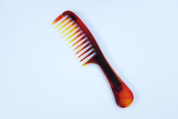 peinar el pelo después del trasplante capilar - vista superior de un peine marrón con los dientes anchos