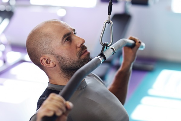 Gimnasio tras injerto capilar - Hombre con alopecia realizando ejercicios en un gimnasio tras injerto de cabello CDMX