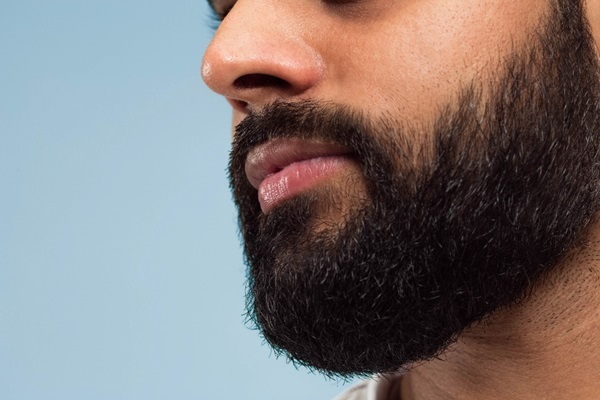 Injerto de barba - Hombre joven de perfil con una barba completa y abundante gracias a un cuidado capilar adecuado luego del implante de barba