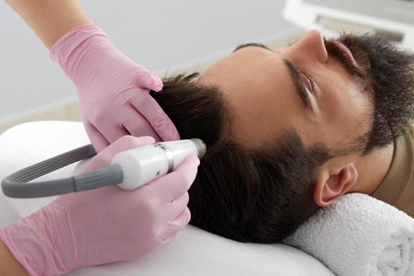 Tratamiento capilar - Médico especialista realizando un tratamiento capilar a un hombre para fortalecer el pelo y estimular el crecimiento del cabello
