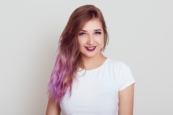 Trucos de cabello - Mujer sonriendo con una combinación de colores en el pelo gracias a los trucos de cabello para rejuvenecer la fibra capilar
