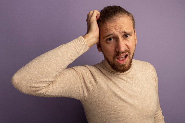 Alopecia frontal fibrosante - Hombre asombrado colocando su mano en la cabeza debido a los síntomas de la alopecia frontal fibrosante que presenta