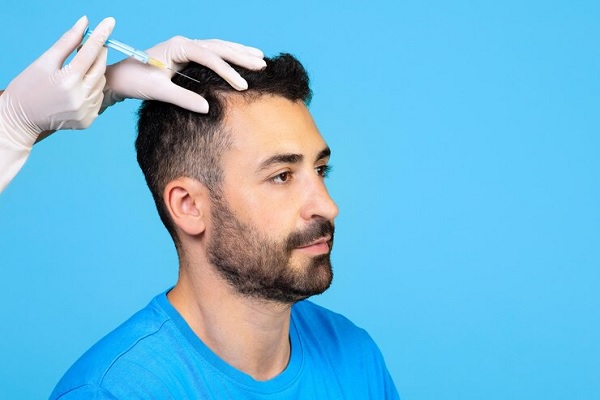 Proceso trasplante cabello - Médico capilar realizando un tratamiento de trasplante de cabello a un hombre con pérdida de pelo en las entradas