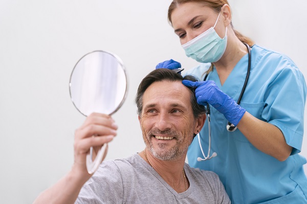 Médico tricólogo evaluando los resultados del injerto de cabello