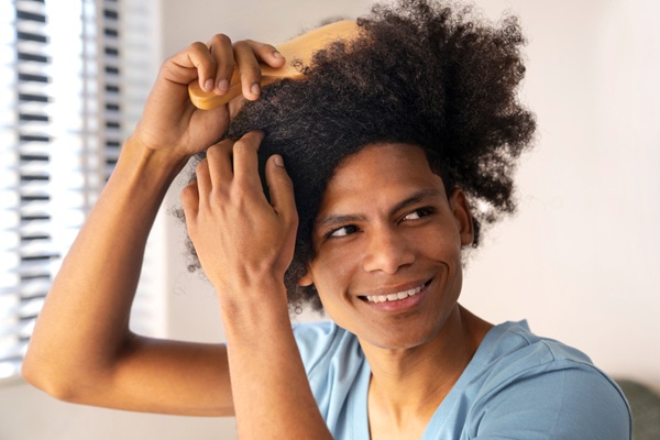 Trasplante cabello rizado - Hombre peinando su cabello rizado abundante luego de un tratamiento injerto cabello CDMX