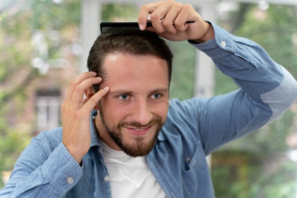 Min Time FUE Zafiro - Hombre feliz peinando su cabello abundante y natural luego de un trasplante de cabello en CDMX