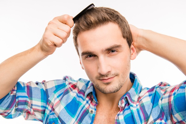 Hombre peinando su cabello abundante y natural luego de un trasplante de cabello exitoso en CDMX